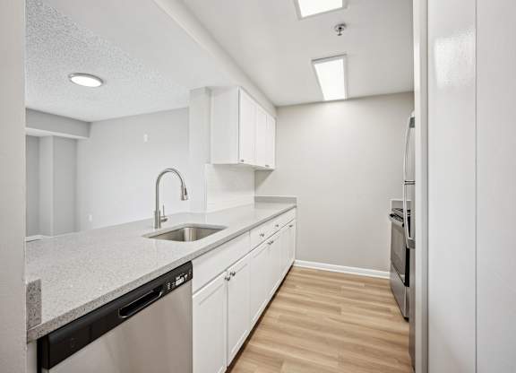 A modern kitchen with white cabinets and a granite countertop.
