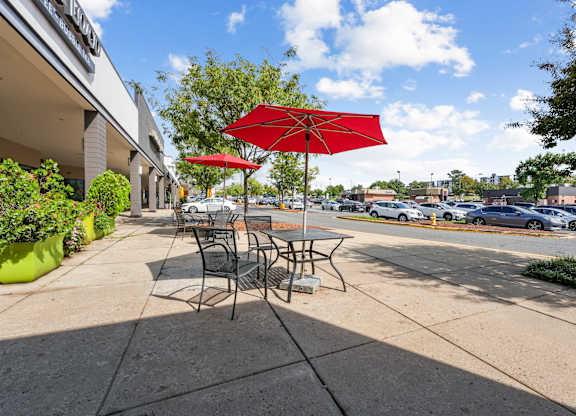 A red umbrella is on a table outside a building at Cascade at Landmark, Virginia