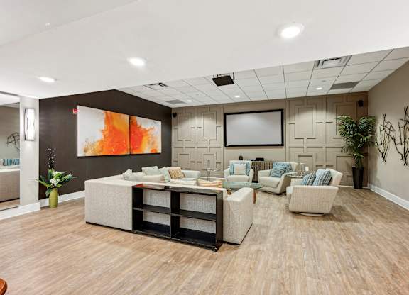 A living room with a large painting on the wall and a TV above the couch.