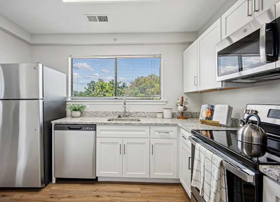 A kitchen with white cabinets and a stainless steel refrigerator at Elme Bethesda, Bethesda, 20814