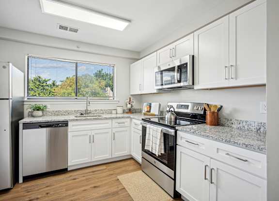 A kitchen with white cabinets and stainless steel appliances at Elme Bethesda, Bethesda, 20814