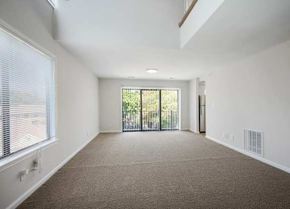 A spacious room with a carpeted floor and a sliding glass door leading to a balcony at Elme Bethesda, Bethesda, 20814