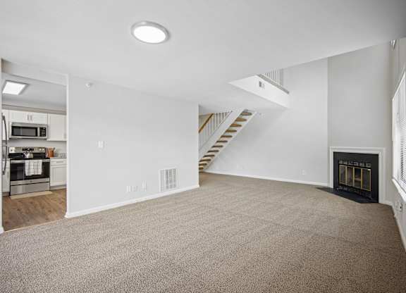 A spacious living room with a fireplace and a staircase at Elme Bethesda, Bethesda, 20814