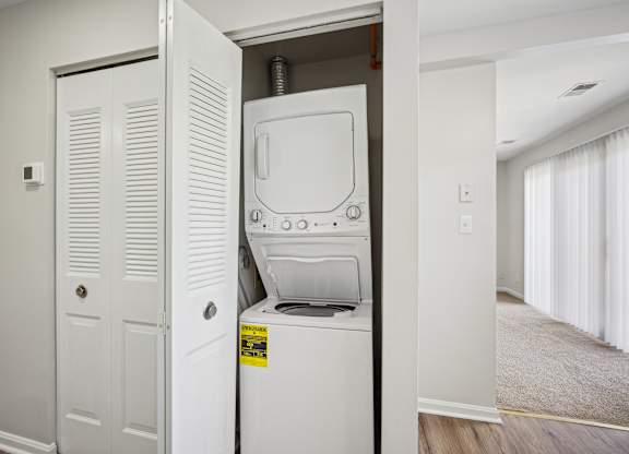 A white washing machine is in a small alcove in a room at Elme Bethesda, Bethesda, 20814
