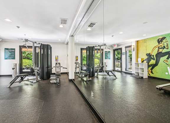 A gym with a variety of equipment including treadmills, weights, and exercise machines.