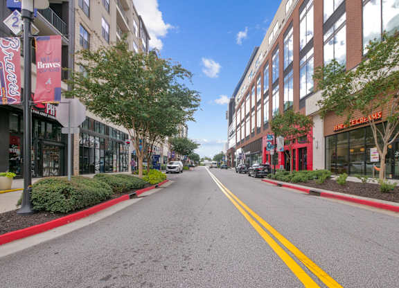 A street with a yellow line down the middle and buildings on either side.