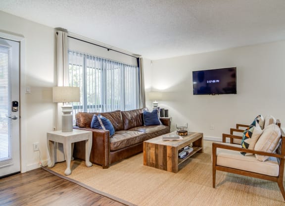 a living room with a couch and a chair and a tv appliances at Elme Cumberland Apartments, Smyrna, Georgia