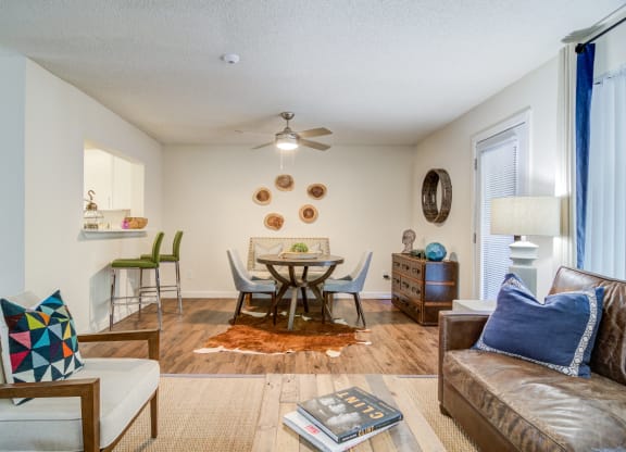 a living room with a couch and a table with chairs at Elme Cumberland Apartments, Smyrna, Georgia