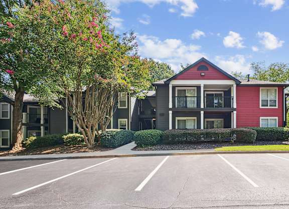A red and grey building with a parking lot in front at Elme Druid Hills, Atlanta, Georgia