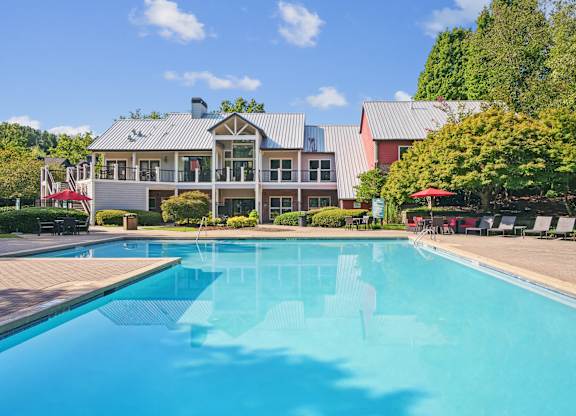 A large swimming pool in front of a building with a red roof at Elme Druid Hills, Atlanta, Georgia