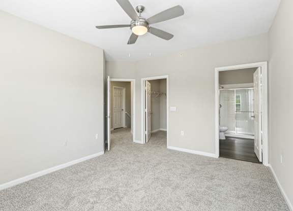 A room with a ceiling fan and carpeted floor.
