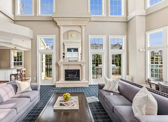 A living room with a grey couch and a fireplace at Elme Dulles, Herndon, VA