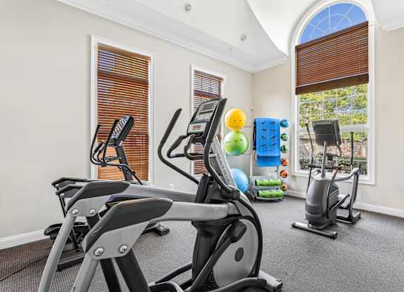 A gym with a row of treadmills and exercise equipment at Elme Dulles, Herndon, VA