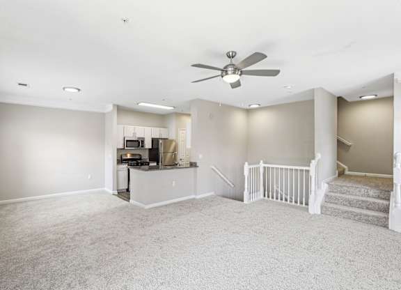 A spacious living room with a staircase leading to the upper floor.