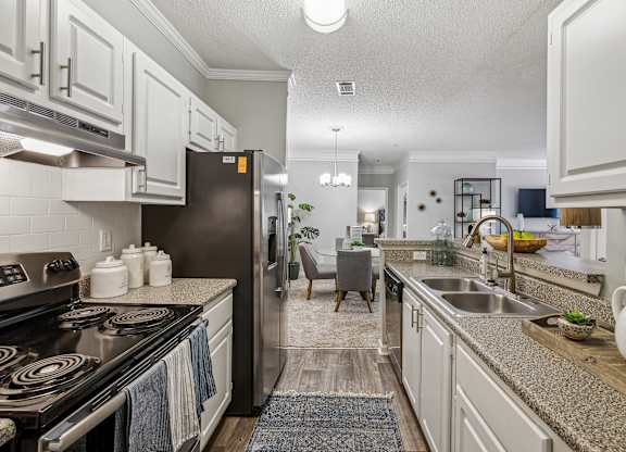 A kitchen with a black stove top oven and white cabinets.