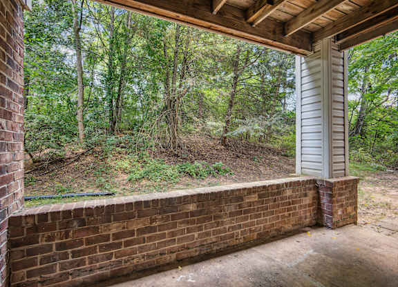 A view from a porch looking out to a wooded area.