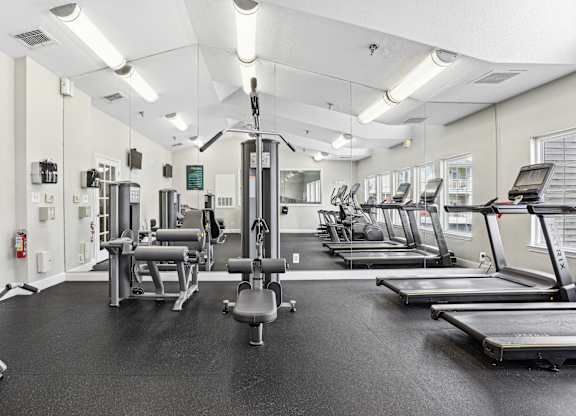 A gym with treadmills, weights, and exercise equipment.