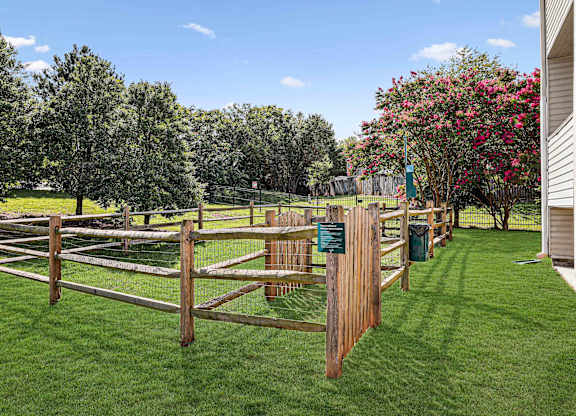 A wooden fence encloses a green lawn.