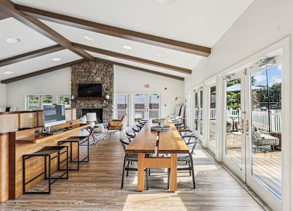 A modern dining room with a stone fireplace and wooden floors at Elme Manassas, Manassas, 20109