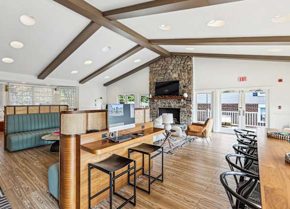 A living room with a stone fireplace and a large window.