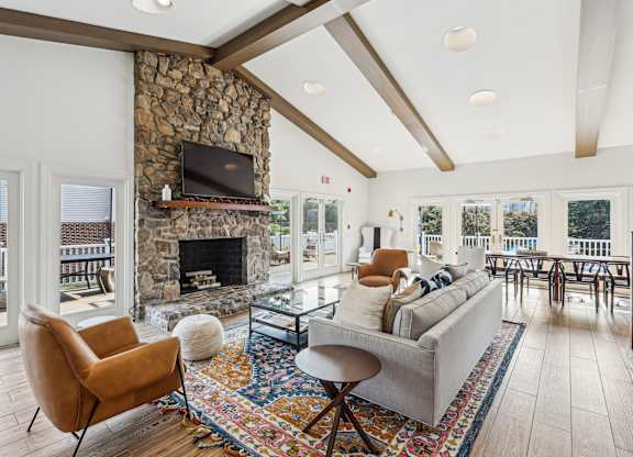 A living room with a stone fireplace and a television above it at Elme Manassas, Manassas, 20109