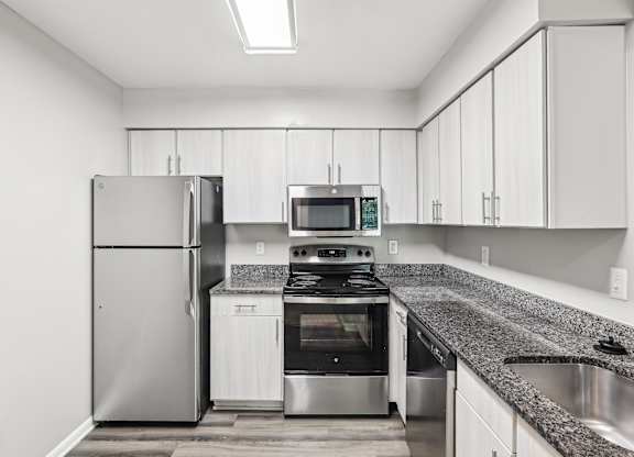 A modern kitchen with a stainless steel refrigerator, oven, and microwave at Elme Manassas, Manassas, 20109