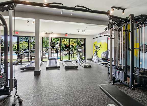 A gym with a variety of equipment including treadmills, weights, and exercise machines.