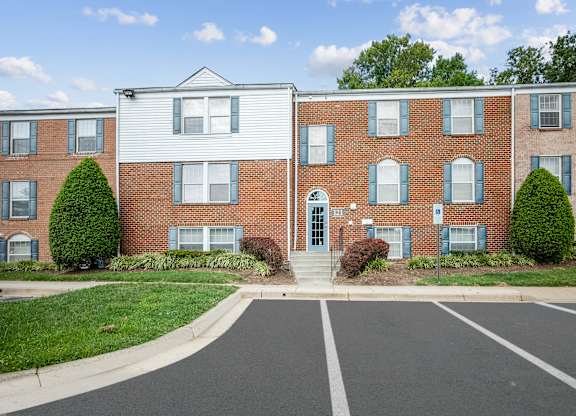 A row of apartment buildings with a parking lot in front at Elme Watkins Mill, Gaithersburg