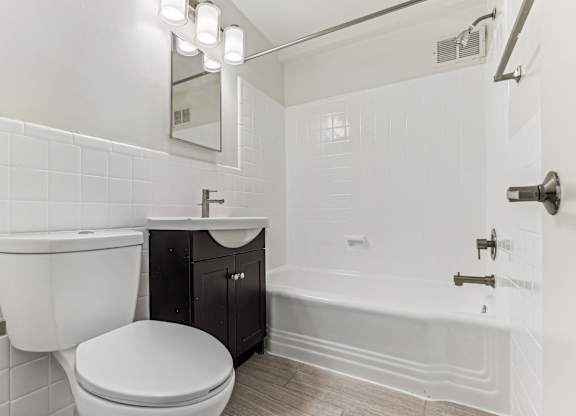 A white bathroom with a toilet, sink, and bathtub.