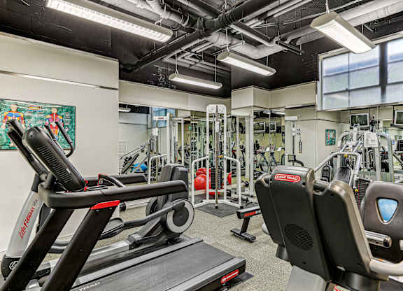 A gym with treadmills, weights, and exercise machines.