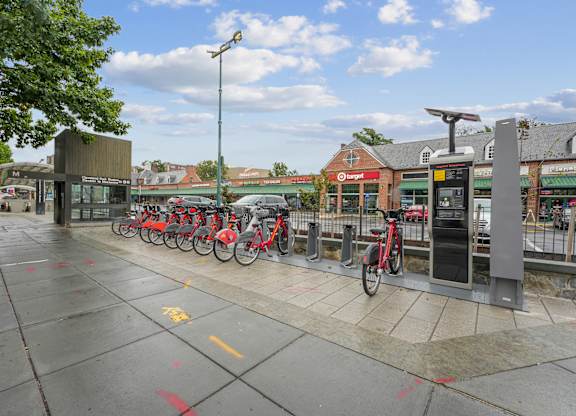 A row of bikes are parked at a bike station.