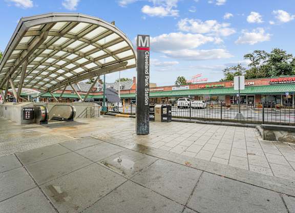 A wet sidewalk leads to a bus stop shelter.