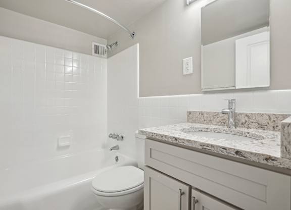 A white bathroom with a tub, toilet and sink at The Kenmore, Washington, 20015