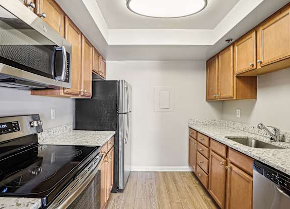 A kitchen with wooden cabinets and black appliances  at The Paramount, Arlington, Virginia