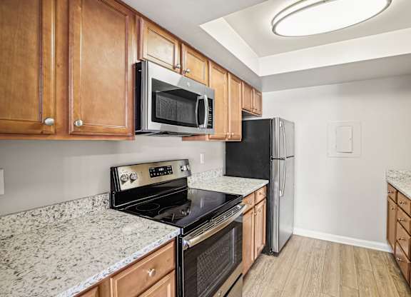 A kitchen with wooden cabinets and black appliances.