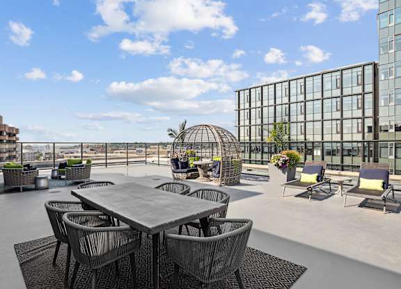 A table surrounded by chairs on a patio with a building in the background  at The Paramount, Arlington, Virginia