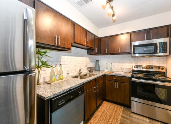 Kitchen with stainless steel appliances and granite countertops at Elme Sandy Springs Apartments, Atlanta, GA