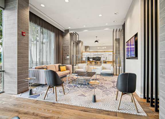 A modern living room with a black chair in the foreground at Riverside Apartments, Alexandria, Virginia