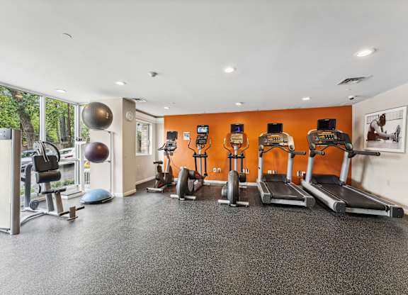 A gym with orange walls and a variety of equipment  at Roosevelt Towers, Falls Church, VA