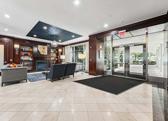 A spacious lobby with a black mat on the floor and a black couch  at Roosevelt Towers, Falls Church, VA