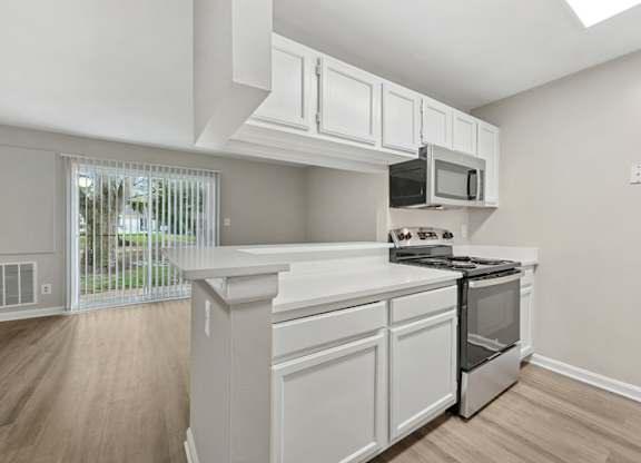 A kitchen with white cabinets and stainless steel appliances.
