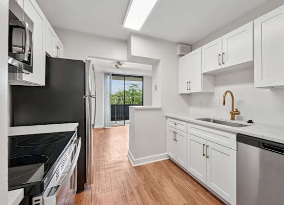 A kitchen with black appliances and white cabinets  at Riverside Apartments, Alexandria, Virginia