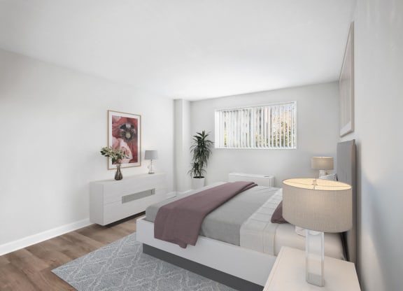 a bedroom with white walls and a bed with a purple blanket at Roosevelt Towers, Falls Church, VA