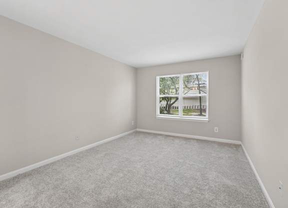 A room with a carpeted floor and a picture frame on the wall.