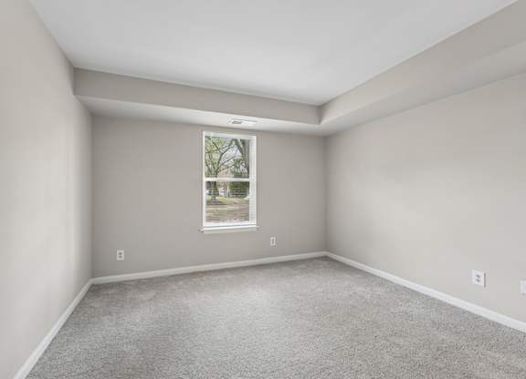 A room with a window showing a tree outside.