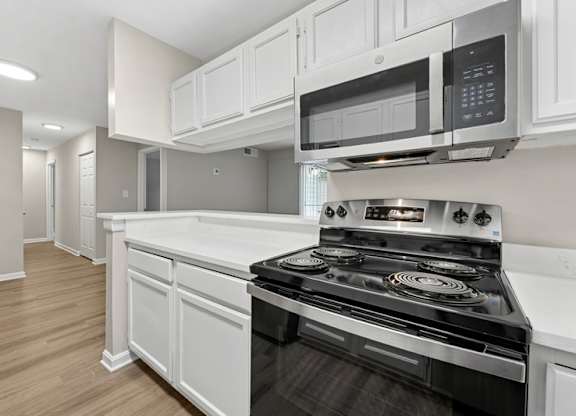 A modern kitchen with a stove and microwave oven.