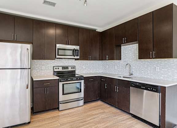 A kitchen with brown cabinets and white appliances.