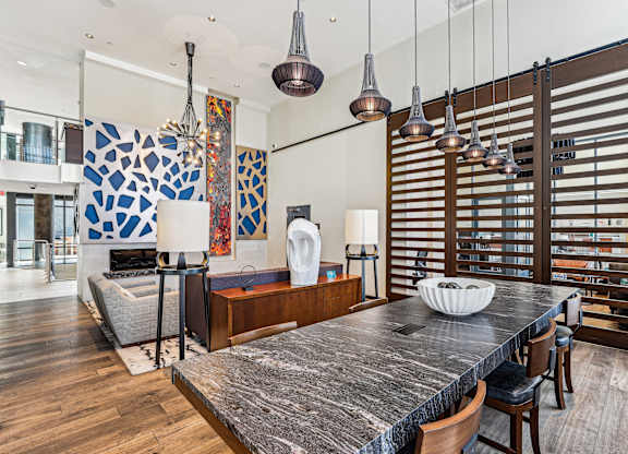 A modern kitchen with a large island and wooden chairs at The Maxwell Apartments, Arlington
