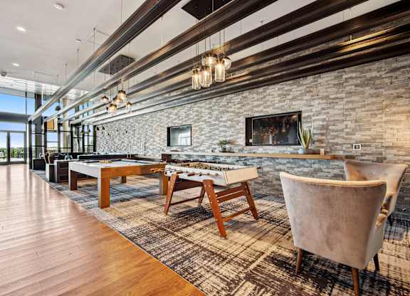 A room with a stone wall and a pool table.
