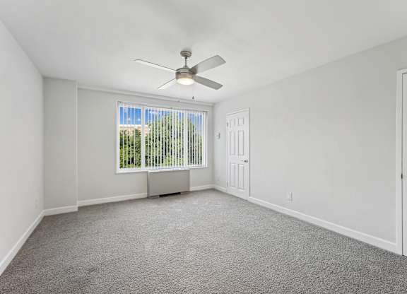 A room with a ceiling fan and a window with blinds at Wellington Apartments, Arlington, Virginia